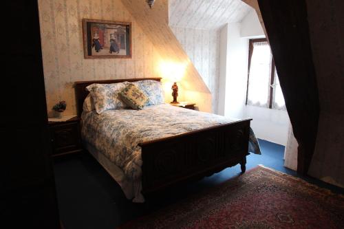 a bedroom with a bed with a lamp and a window at Manoir du Mur in Comblessac