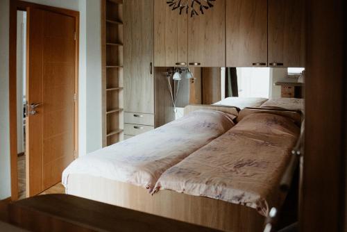 Apartman Hana في Gornja Toplica: سرير كبير في غرفة بها دواليب خشبية
