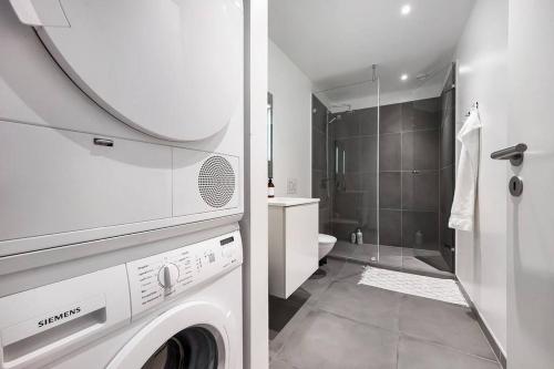 a bathroom with a washing machine and a shower at Boutique apartment in Citycenter in Copenhagen