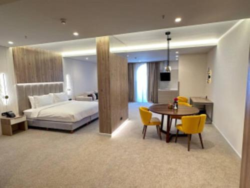 1 dormitorio con 1 cama, mesa y sillas en Apart Hotel Istaravshan, en Tashkent