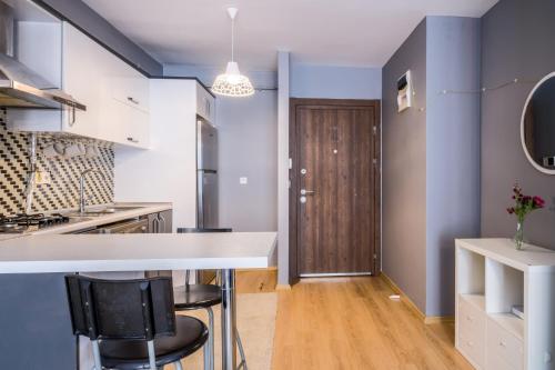 a kitchen with blue walls and a counter with stools at Flat 10 min to Vadistanbul Mall and Ataturk Forest in Istanbul