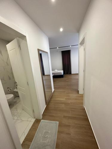 a hallway with a bathroom with a toilet and a mirror at Suite Hotel in Shëngjin