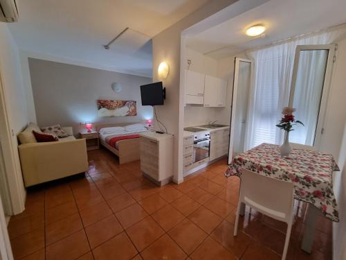 una pequeña sala de estar con cama y mesa. en Residence Alba, en Riccione