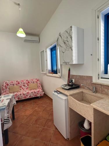 een keuken met een wastafel en een bank in een kamer bij Turismo Egadi - Appartamenti in Favignana