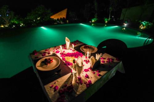 a table with a plate of food next to a pool at Ravishing Retreat Resort in Rāmanagaram
