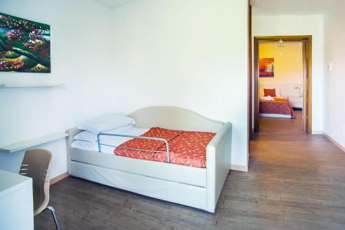 a bedroom with a white bed with a red blanket at Hotel Il Castello in Pozzolengo