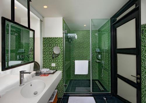 a green bathroom with a sink and a shower at Welcomhotel By ITC Hotels, Guntur in Guntūr