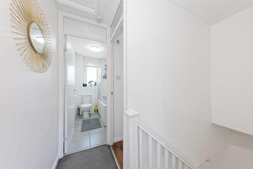 Baño blanco con espejo y aseo en Comfortable Home in Kent, Sleeps 6 - Parking Available, en Kent