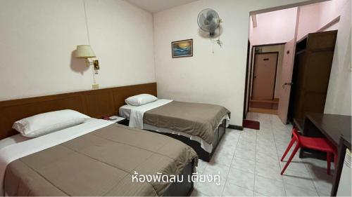 Cette chambre comprend 2 lits et une télévision. dans l'établissement Thaen Thong Hotel, à Lamphun
