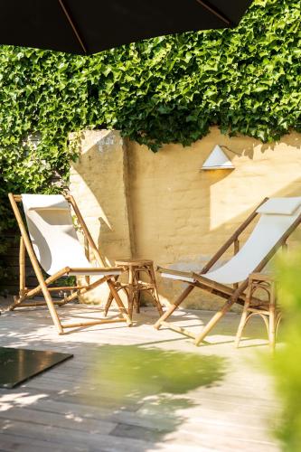 twee stoelen en een tafel op een patio bij Villa Francine in Deinze