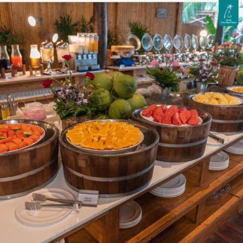 a buffet with oranges and other fruits in wooden barrels at Phi Phi CoCo Beach Resort in Phi Phi Don