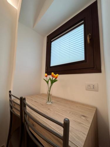 a vase of flowers on a table with a window at Nonna Cia in Gallipoli