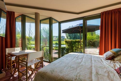 1 dormitorio con cama, escritorio y puertas de cristal en Villa Francine, en Deinze