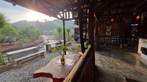 a table in a building with a view of a river at Enter Point in Bukit Lawang