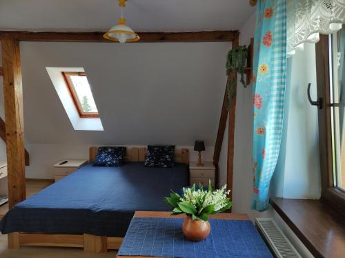 een slaapkamer met een blauw bed en een tafel bij Domek i pokoje Wilkasy in Wilkasy