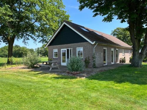 a small house with a picnic table in the yard at Gastenverblijf WeijdeBlik in Sinderen