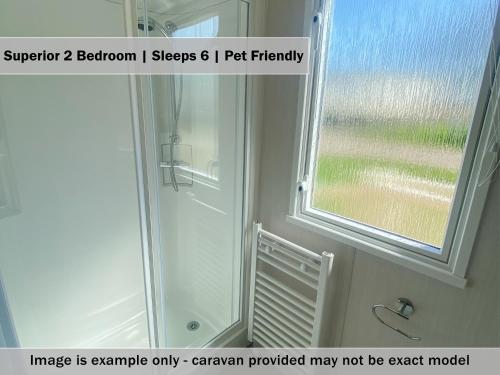 a shower in a bathroom with a window at Crows Nest Caravan Park in Filey