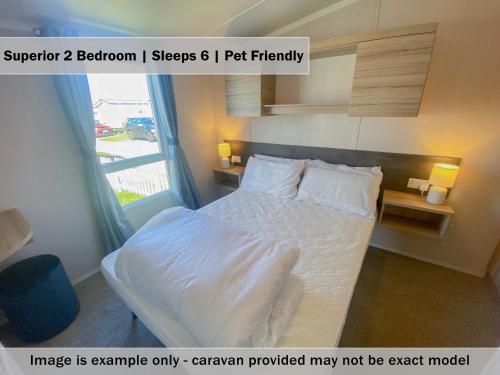 sypialnia z łóżkiem i oknem w obiekcie Crows Nest Caravan Park w mieście Filey