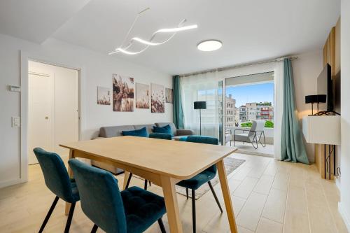 a dining room and living room with a table and chairs at Magical 2BR Condo in the Heart of Cambrils in Cambrils
