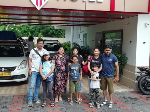 a family poses for a picture in front of a gas station at MARINA SUITES AIRPORT HOTEL in Cochin