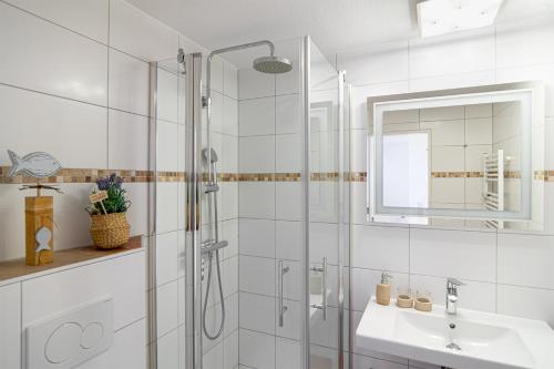 a white bathroom with a shower and a sink at Panorama Schönberger-Strand Appartement 21 in Stakendorfer Strand