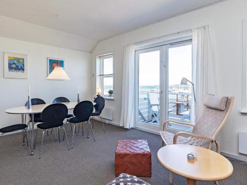 a living room with a table and chairs and a window at Holiday home Rudkøbing XX in Rudkøbing