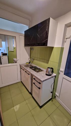 a kitchen with white cabinets and a stove top oven at Studio Unikat in Braşov