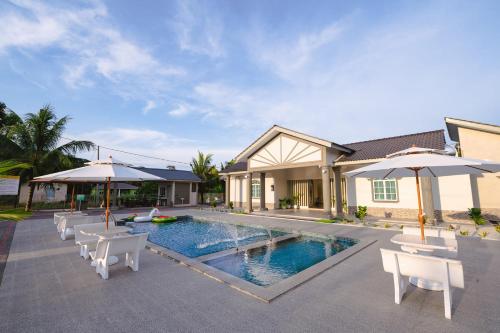 uma casa com piscina com cadeiras e guarda-sóis em Villa Dracaena Melaka - Private Pool, Hill View, 20 minutes to Town em Kampong Bukit Katil