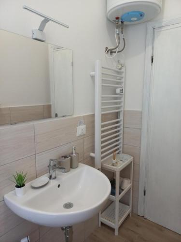 y baño con lavabo blanco y espejo. en Grazioso Bilocale Caletta Castiglioncello - Tuscany en Castiglioncello