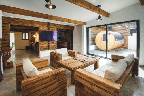 sala de estar con muebles de madera y ventana grande en The Hut Retreat, en Fîntînele