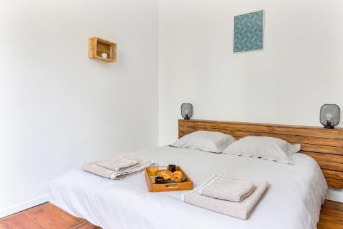 a white bed with a tray of fruit on it at Gambetta 302 CahorsCityStay in Cahors