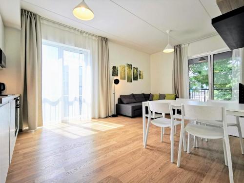 a kitchen and living room with a table and chairs at Scandian Apartments - City Hub Tallinn in Tallinn