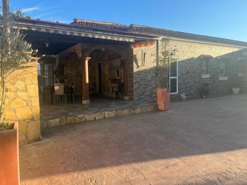 a stone house with a patio in front of it at Chalet , a 6km de la playa in Chiclana de la Frontera