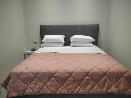 a bedroom with a large bed with a pink quilt at Corfu Glyfada Menigos Resort Home 72 in Glyfada