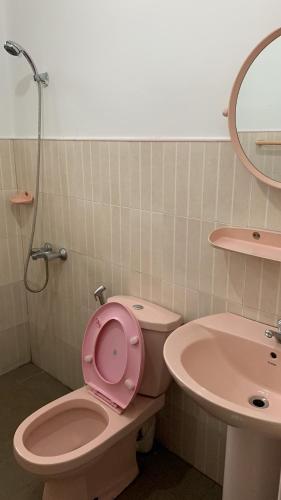 a bathroom with a pink toilet and a sink at Paramount Hotel Pussellawa in Pussellawa