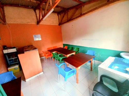 a room with a table and chairs and a kitchen at Talanta Ajira Cottages in Kisumu