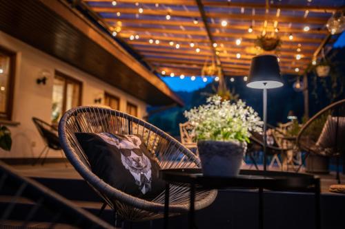 a patio table with chairs and a lamp and flowers at Engel 16 in Gutach