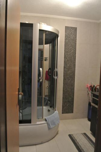ein Bad mit einer Dusche und einem Spiegel in der Unterkunft Heart of Sarajevo - Bakarevica luxury apartman in Sarajevo