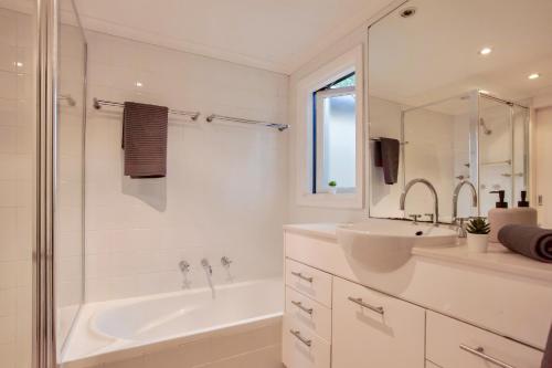a white bathroom with a tub and a sink at 3 Bedrooms - Darling Harbour - Darling St 2 E-Bikes Included in Sydney