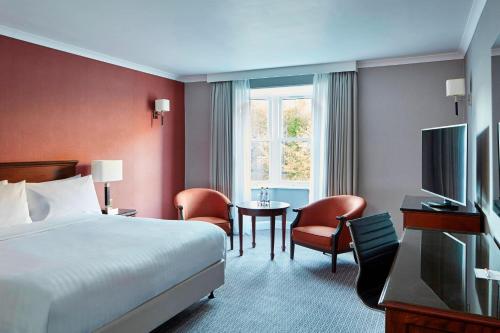 una camera d'albergo con letto, tavolo e sedie di Delta Hotels by Marriott Durham Royal County a Durham