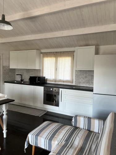 una cucina con mobili bianchi e una stufa di S' Ispantu a Olbia