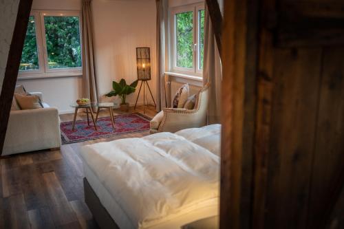 a bedroom with a bed and a living room with windows at Engel 16 in Gutach