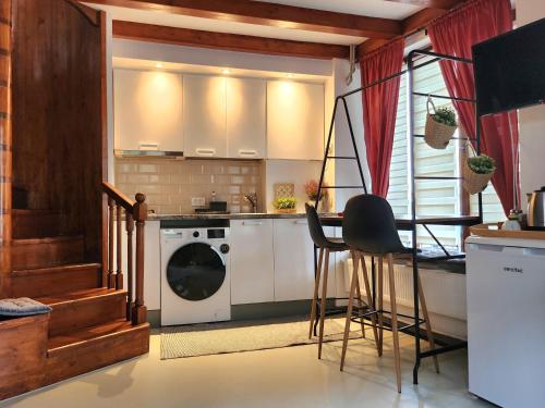 a kitchen with a washing machine and a table and chairs at Lovely Studio in center of Bucharest in Bucharest