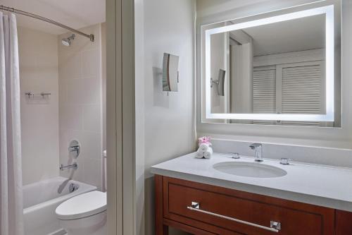 a bathroom with a sink and a toilet and a mirror at Sheraton Kauai Resort Villas in Koloa