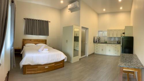 a bedroom with a large bed and a kitchen at Bulan Biru in Kuta Lombok