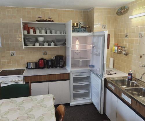 a kitchen with a white refrigerator and a sink at Ferienhaus Wechner in Häselgehr