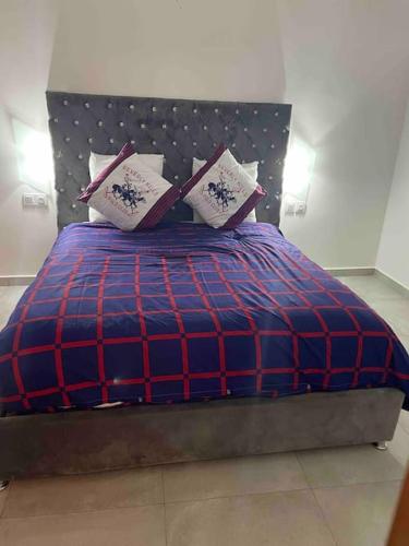 a blue and red bed with pillows on it at villa aya in Saïdia