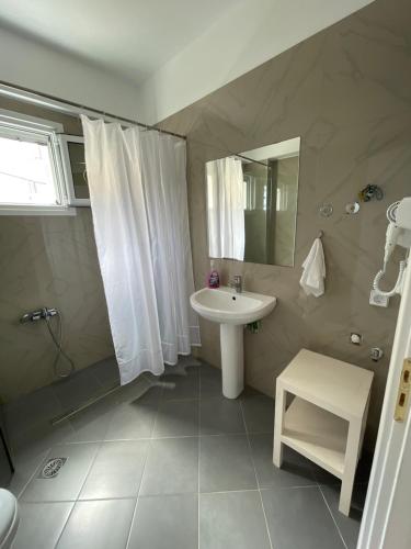 y baño con lavabo blanco y espejo. en Horizon view rooms en Himare
