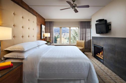 雅芳的住宿－Sheraton Lakeside Terrace Villas at Mountain Vista, Avon, Vail Valley，酒店客房配有一张床和一个壁炉。