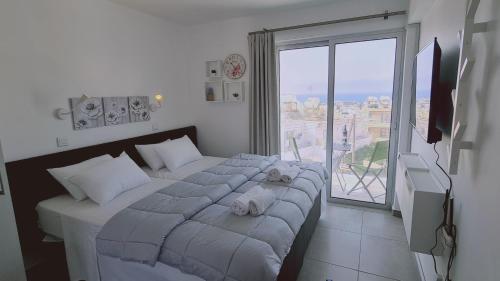 a bedroom with a bed and a large window at STAY Napa Living Studios in Ayia Napa